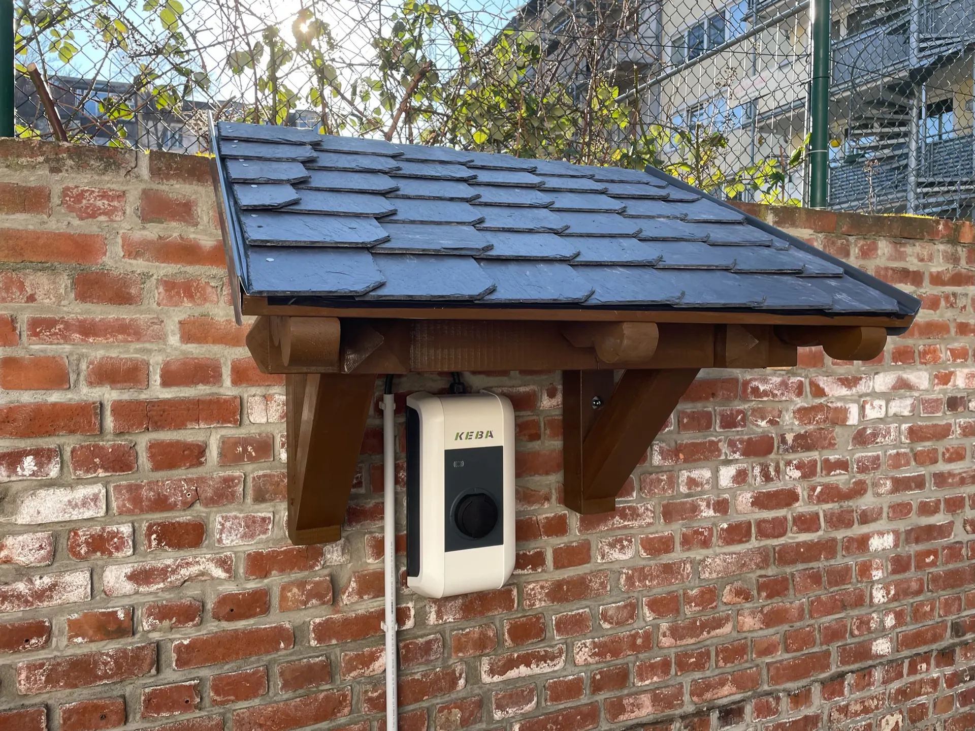 Vordach in Holz mit Schieferdach an Backsteinwand