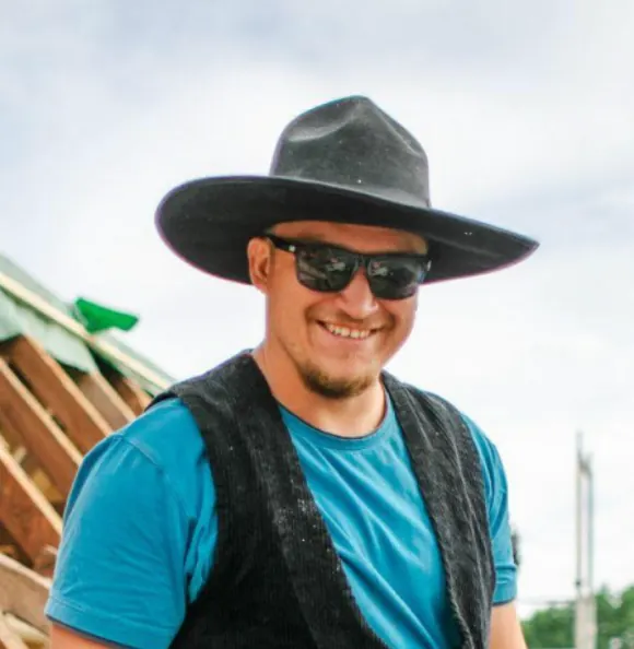Ludwig Pappelbaum auf einem Dachstuhl, in traditioneller Zimmermanns-Zunftkleidung
